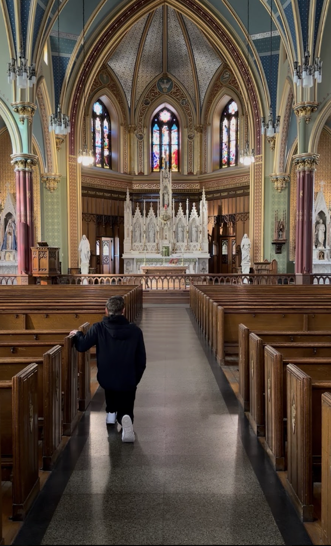 Grady Connolly kneeling in the nave of a Gothic basilica