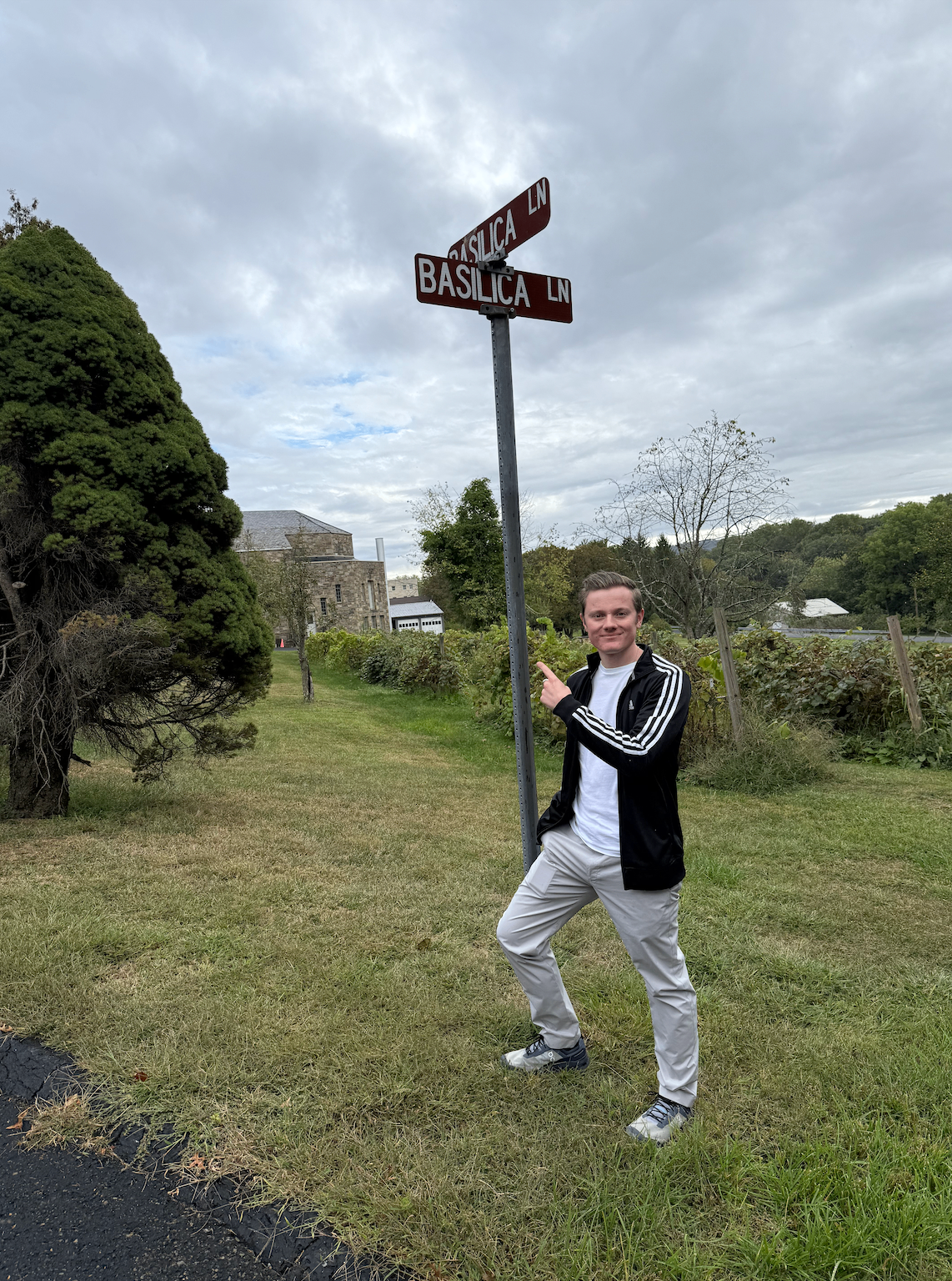 Grady Connolly pointing to a street sign reading Basilica Lane